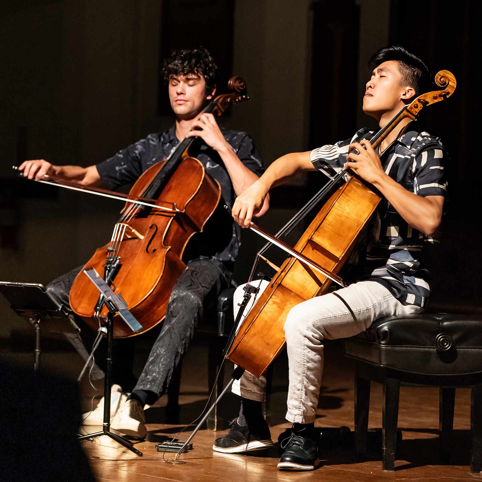 Two cellists perform onstage during a Cecilia Concerts chamber music performance, featured on the About page.