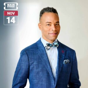 Portrait of a man wearing a blue plaid suit jacket, light blue shirt, and patterned bow tie against a light neutral background. A Main Stage Concerts graphic in the upper left displays the date November 14.
