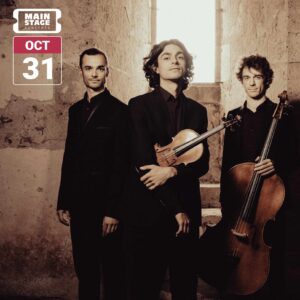 Trio Hélios members Alexis Gournel, Luka Ispir, and Raphaël Jouan pose with violin and cello in a stone interior, dressed in black.